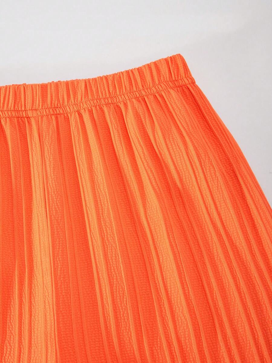 Tween girl wearing an apricot 2-piece outfit set featuring a shirred spaghetti strap short cami top and matching wide-leg long pants.