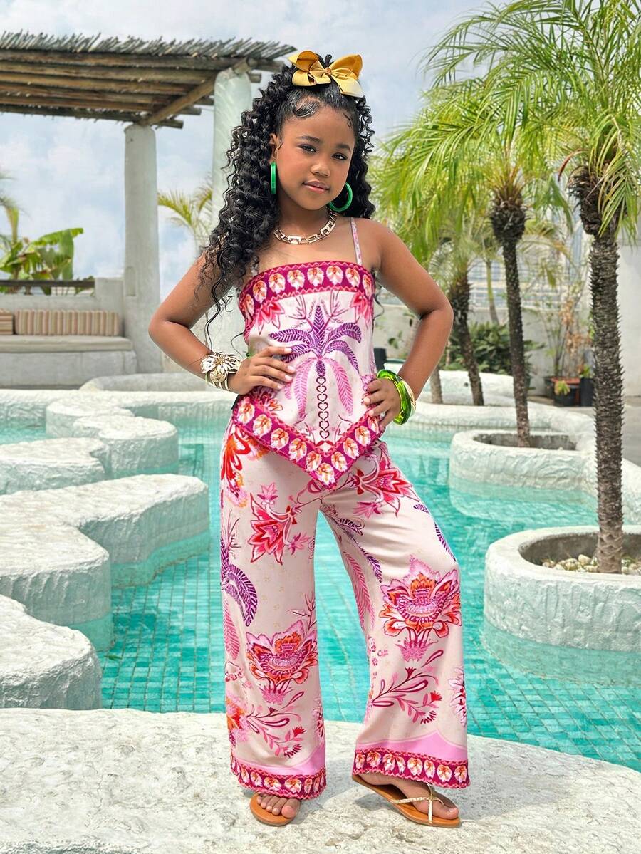 Tween girl wearing a pink boho floral printed 2-piece set with a spaghetti strap cami top and matching belted high-waist long pants.