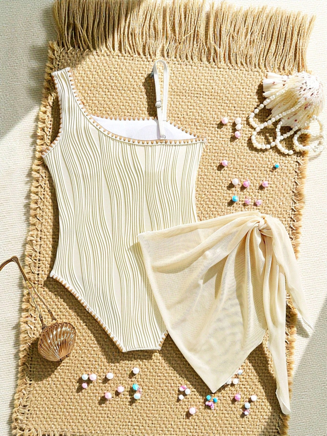 Apricot tween girls one-piece swimsuit with asymmetrical neckline, sleeveless cut, graphic starfish accents, and side-tie short sarong skirt for beach vacations