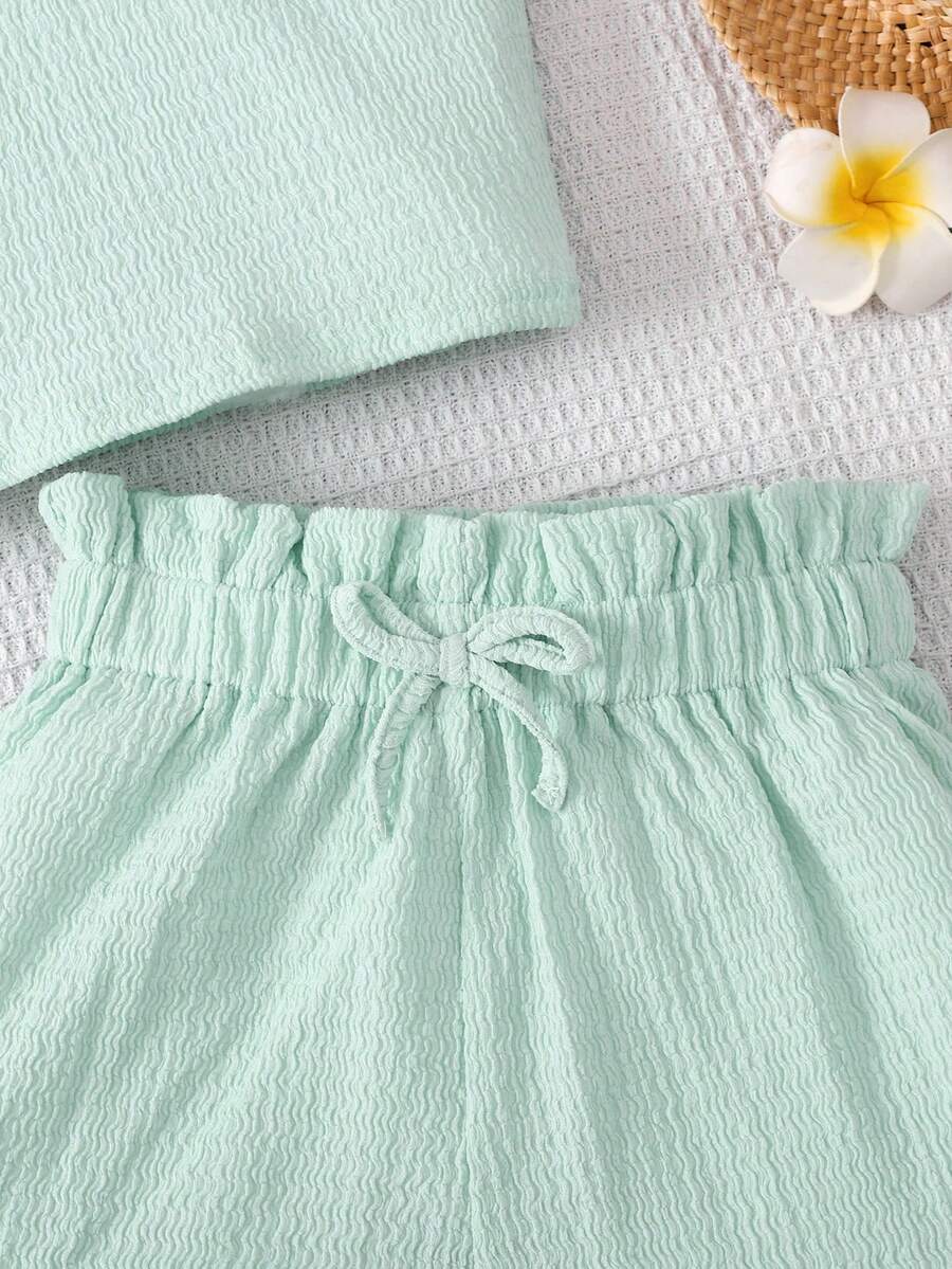 Tween girl 2-piece casual outfit set featuring a solid beige knit halter sleeveless top with belted detail and matching shorts.