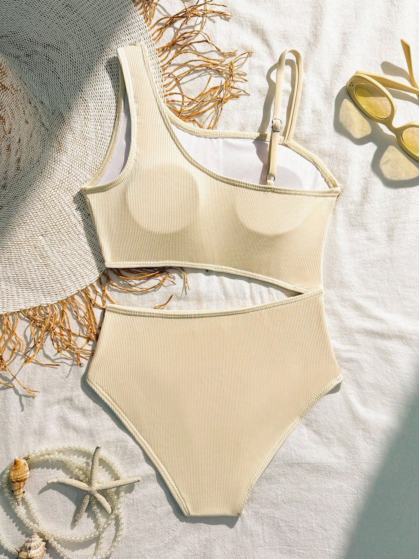 Girls black one-piece swimsuit with asymmetrical neckline, cutout waist detail, colorblock design, and medium-stretch swimsuit fabric for beach and pool wear.