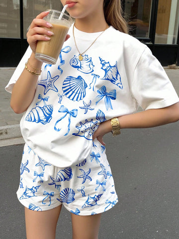 Teen girl wearing 2-piece summer vacation set with blue and white striped short sleeve top featuring seashell ocean bow print and matching loose fit shorts with pockets.