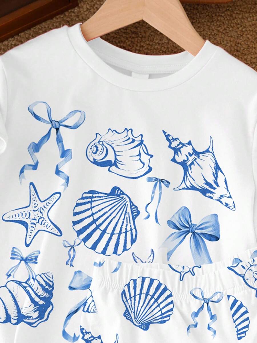 Teen girl wearing 2-piece summer vacation set with blue and white striped short sleeve top featuring seashell ocean bow print and matching loose fit shorts with pockets.