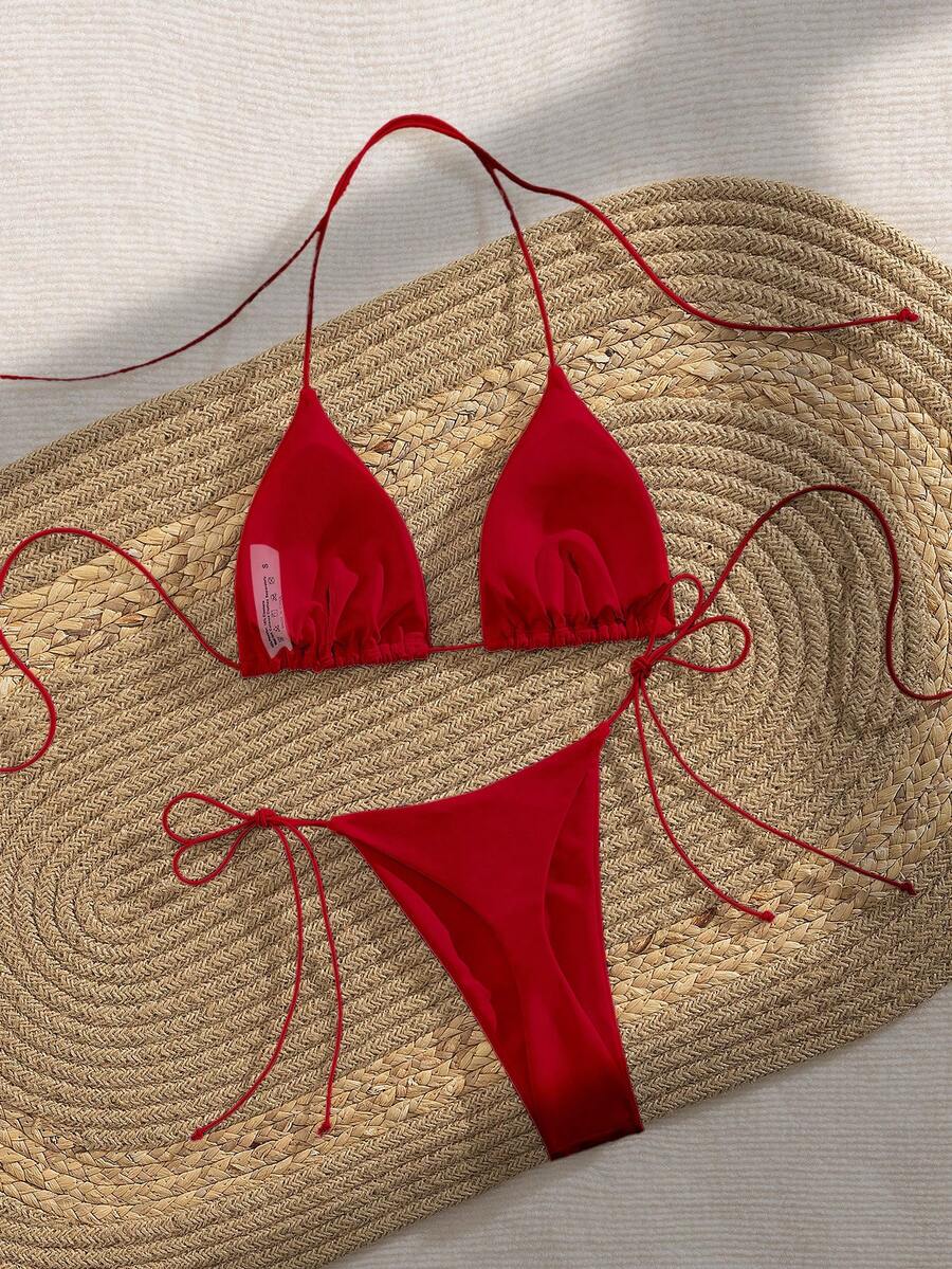 Women's 2-piece bikini set featuring a backless halter triangle top and tie-side ultra low waist bottoms.