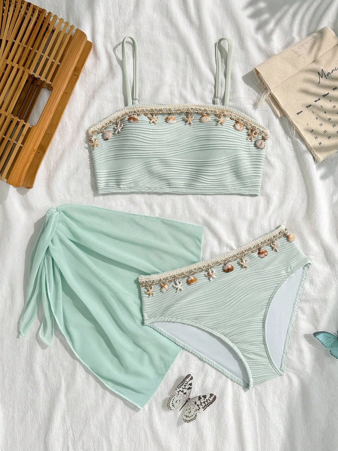 Tween girls bikini set with shell and starfish woven band details, spaghetti strap sleeveless top, and mid-waist skirt-style bottom in blue.