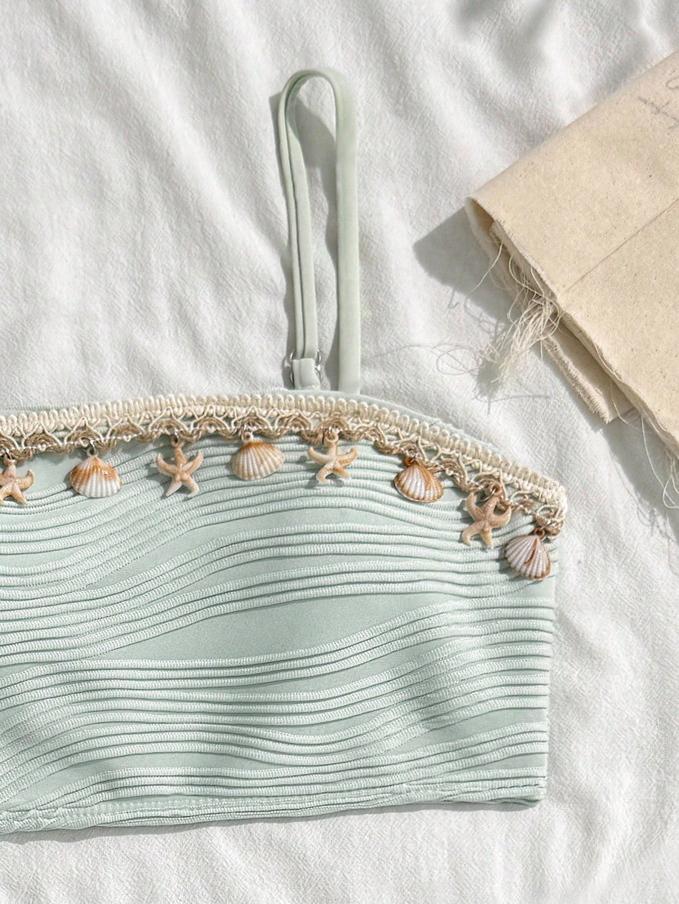 Tween girls bikini set with shell and starfish woven band details, spaghetti strap sleeveless top, and mid-waist skirt-style bottom in blue.