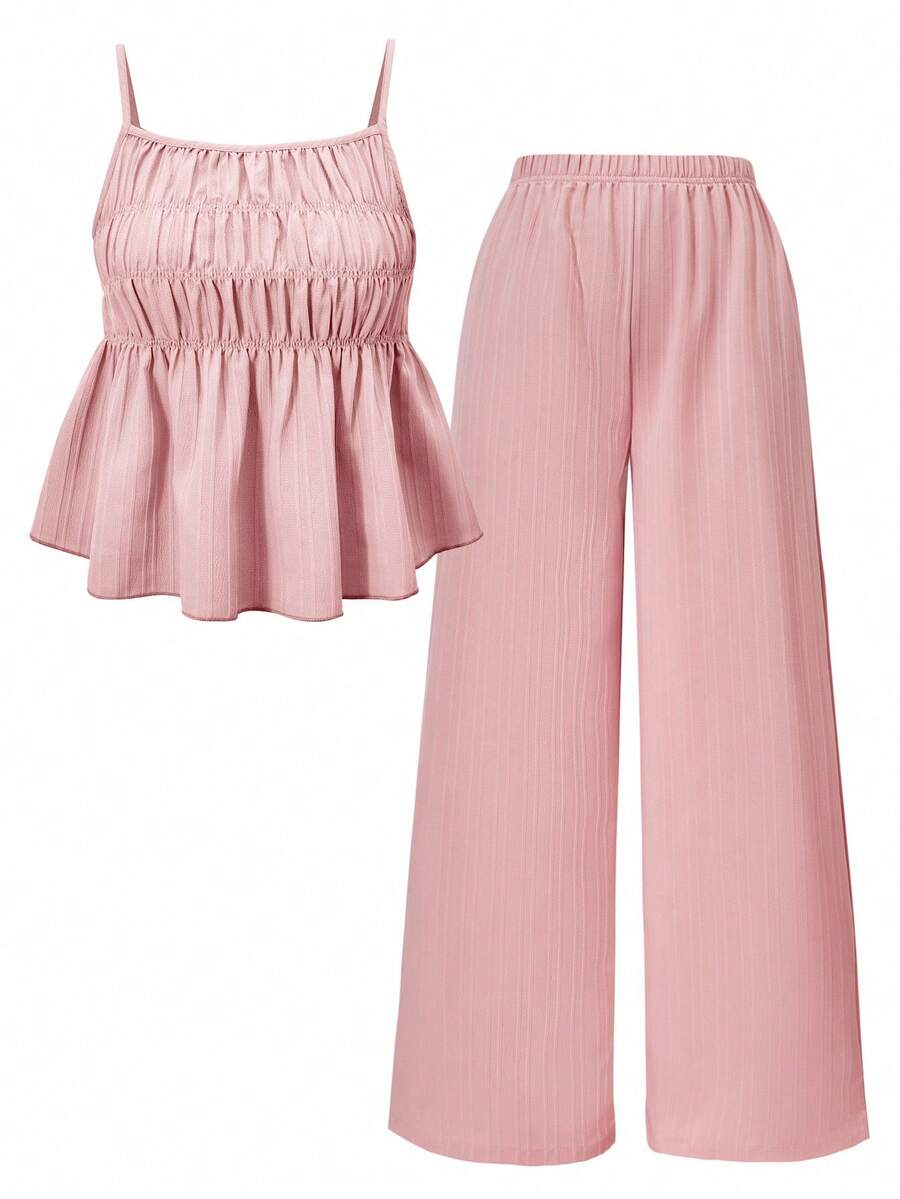 Tween girl wearing an apricot 2-piece outfit set featuring a shirred spaghetti strap short cami top and matching wide-leg long pants.
