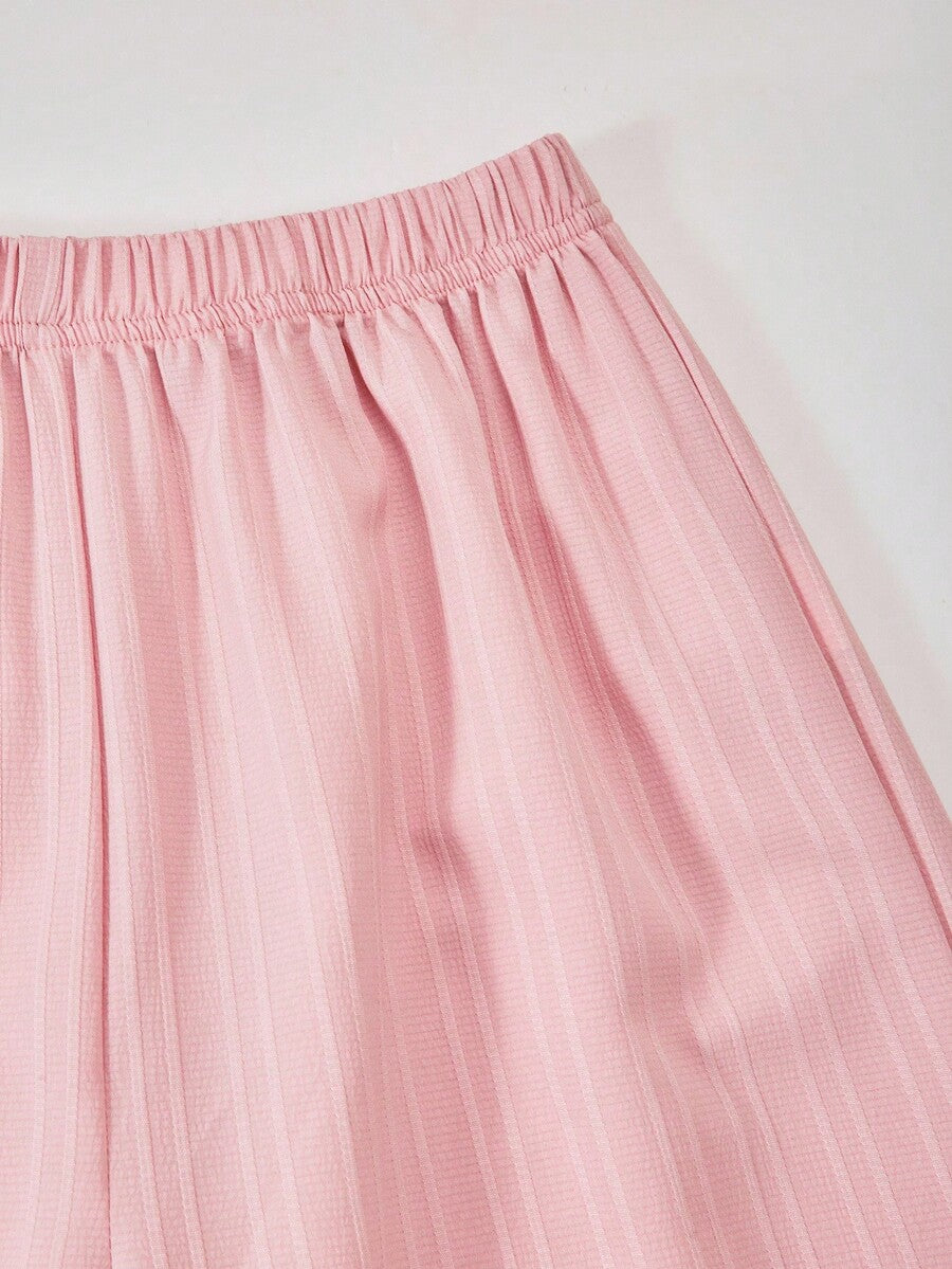 Tween girl wearing an apricot 2-piece outfit set featuring a shirred spaghetti strap short cami top and matching wide-leg long pants.