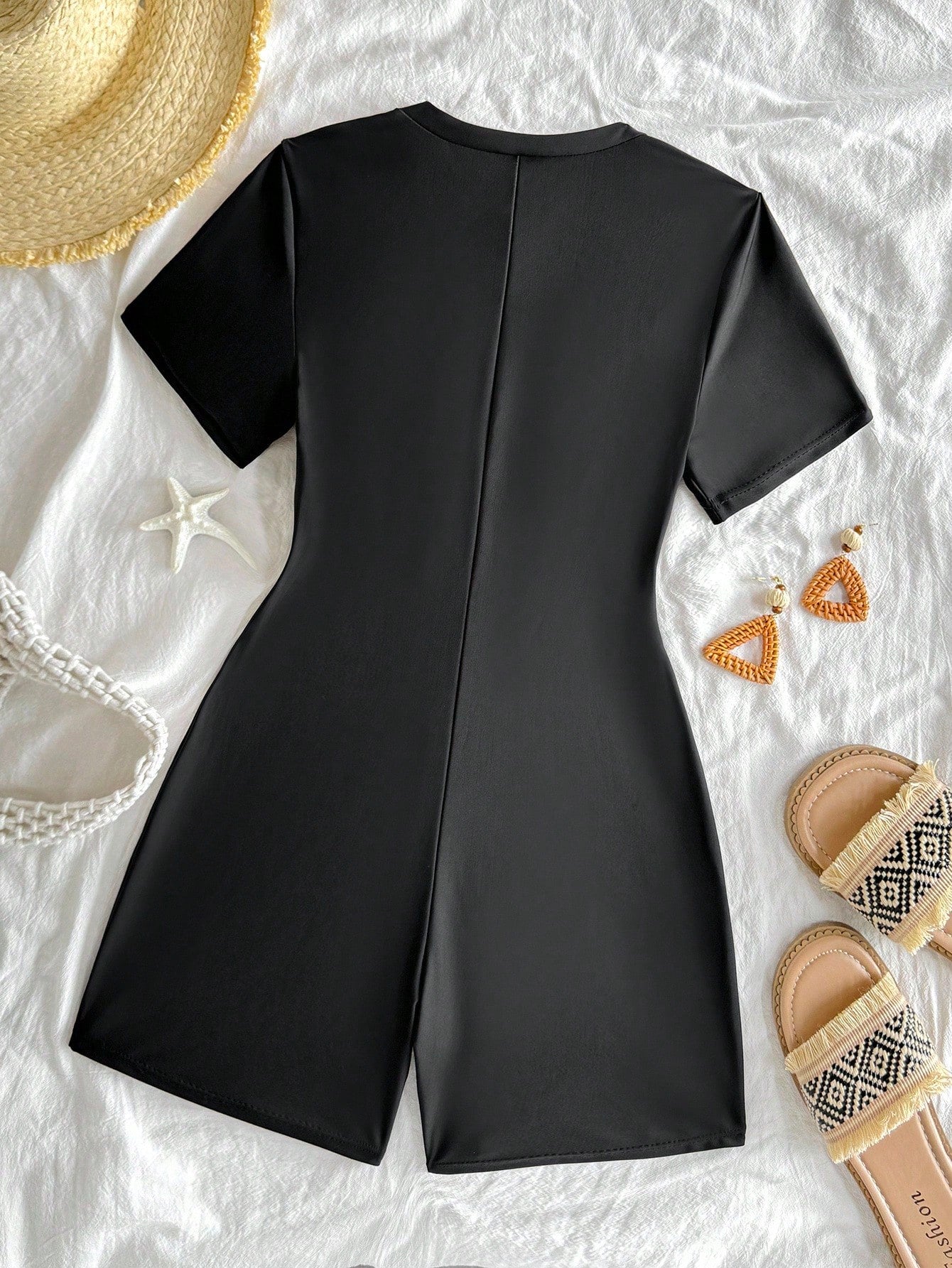 Black and white one-piece rashguard swimsuit for tween girls with short sleeves, high neck, zipper detail, fitted shape, and shorts-style bottom.