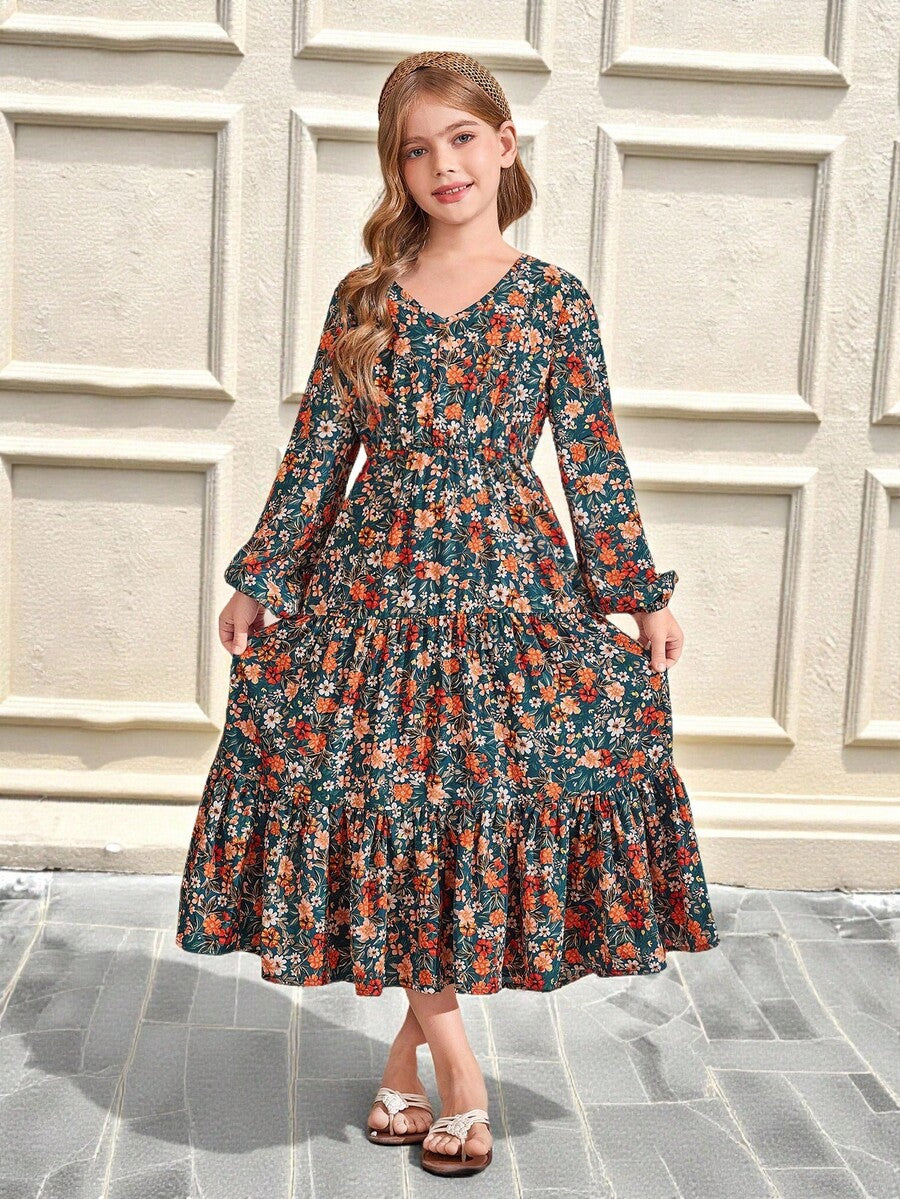 Tween girl wearing an apricot ditsy floral V-neck midi dress with long bishop puff sleeves, tiered ruffle layers, and a flounce hem.