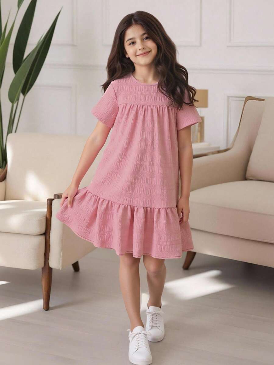 Tween girl wearing an Army Green textured short sleeve smock midi dress with round neck and ruffle flounce hem.