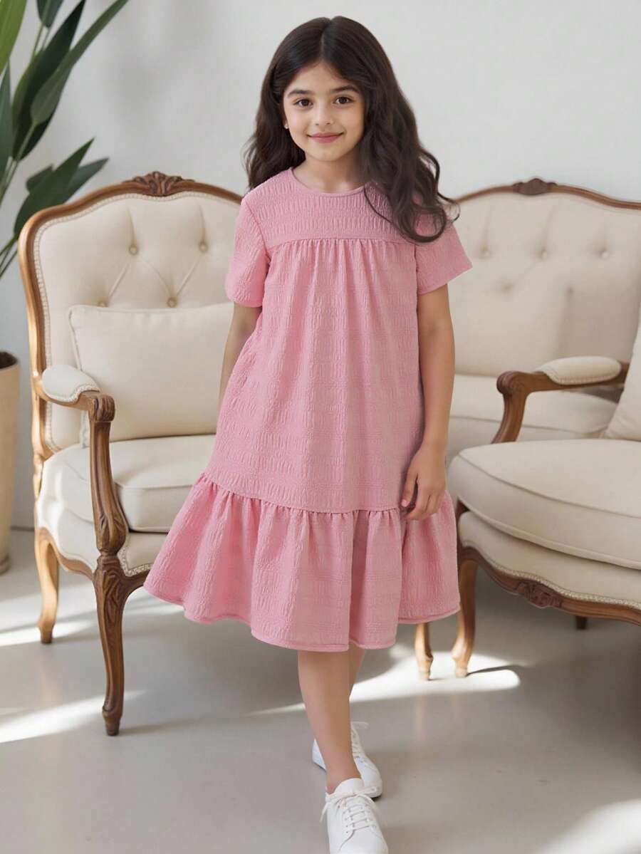 Tween girl wearing an Army Green textured short sleeve smock midi dress with round neck and ruffle flounce hem.