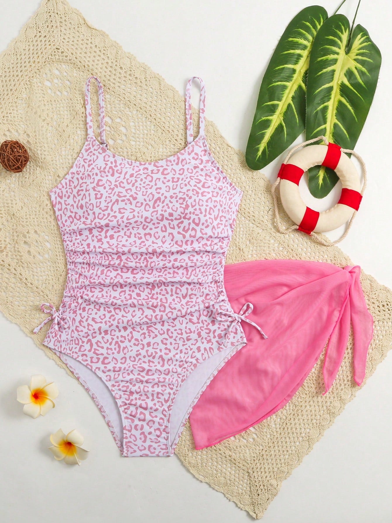Tween girls 2-piece swimsuit in black with pink floral print, featuring spaghetti straps, bow decor, mesh detail, and a skirted mid-waist bottom. Sleeveless vacation-style swim set with medium-stretch fabric.
