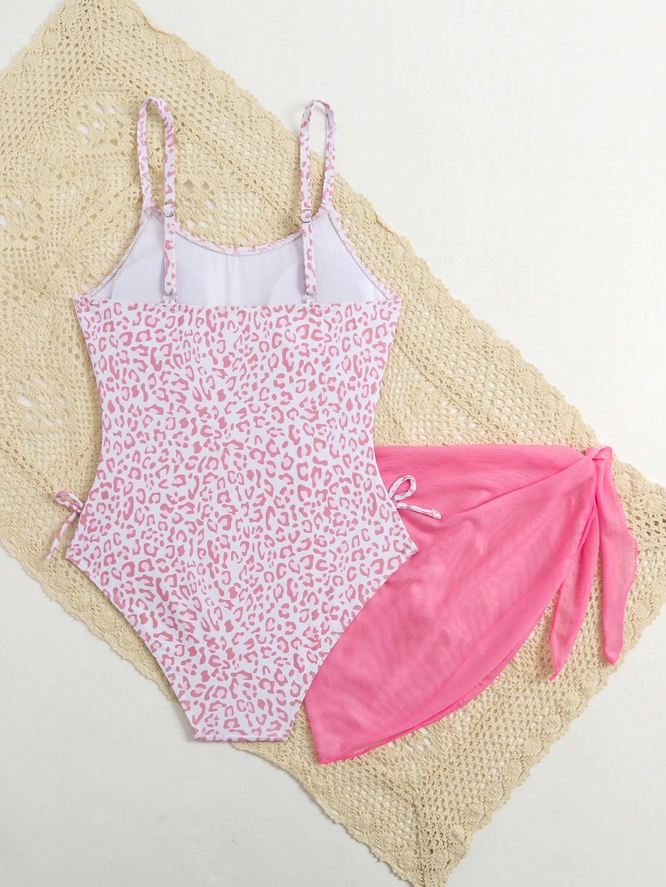 Tween girls 2-piece swimsuit in black with pink floral print, featuring spaghetti straps, bow decor, mesh detail, and a skirted mid-waist bottom. Sleeveless vacation-style swim set with medium-stretch fabric.