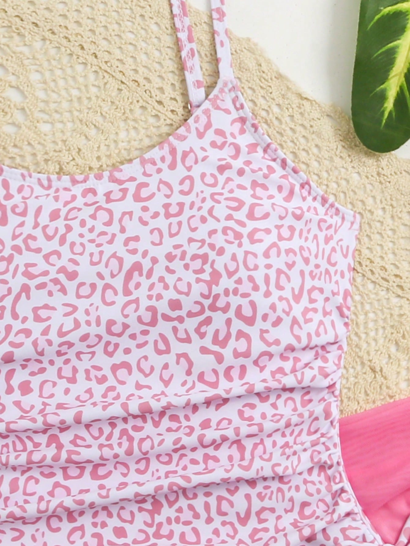 Tween girls 2-piece swimsuit in black with pink floral print, featuring spaghetti straps, bow decor, mesh detail, and a skirted mid-waist bottom. Sleeveless vacation-style swim set with medium-stretch fabric.