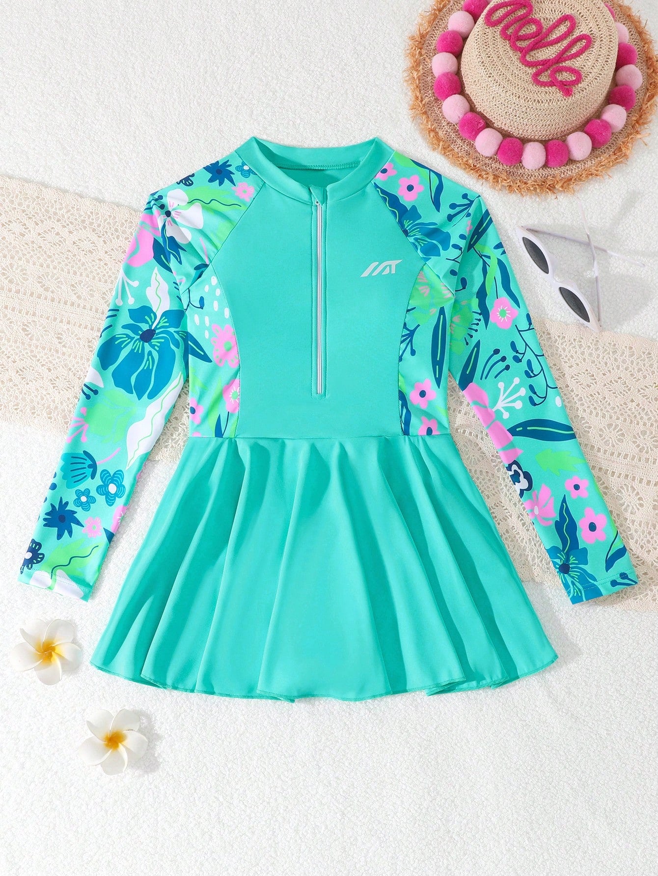 Tween girls one-piece swimsuit in black floral pattern with long sleeves, high neck, front zipper, and a skirt-style bottom.