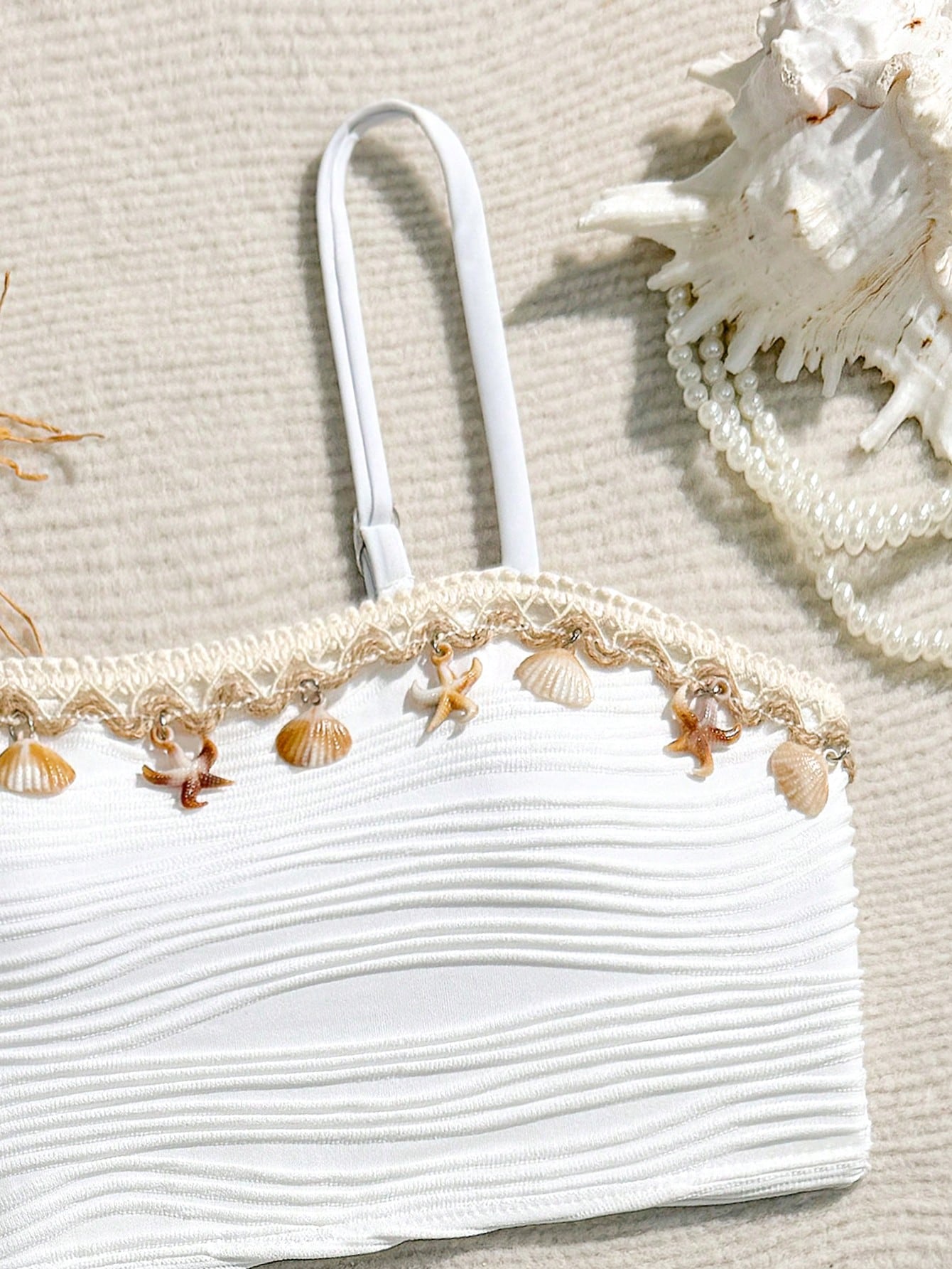 Tween girls bikini set with shell and starfish woven band details, spaghetti strap sleeveless top, and mid-waist skirt-style bottom in blue.