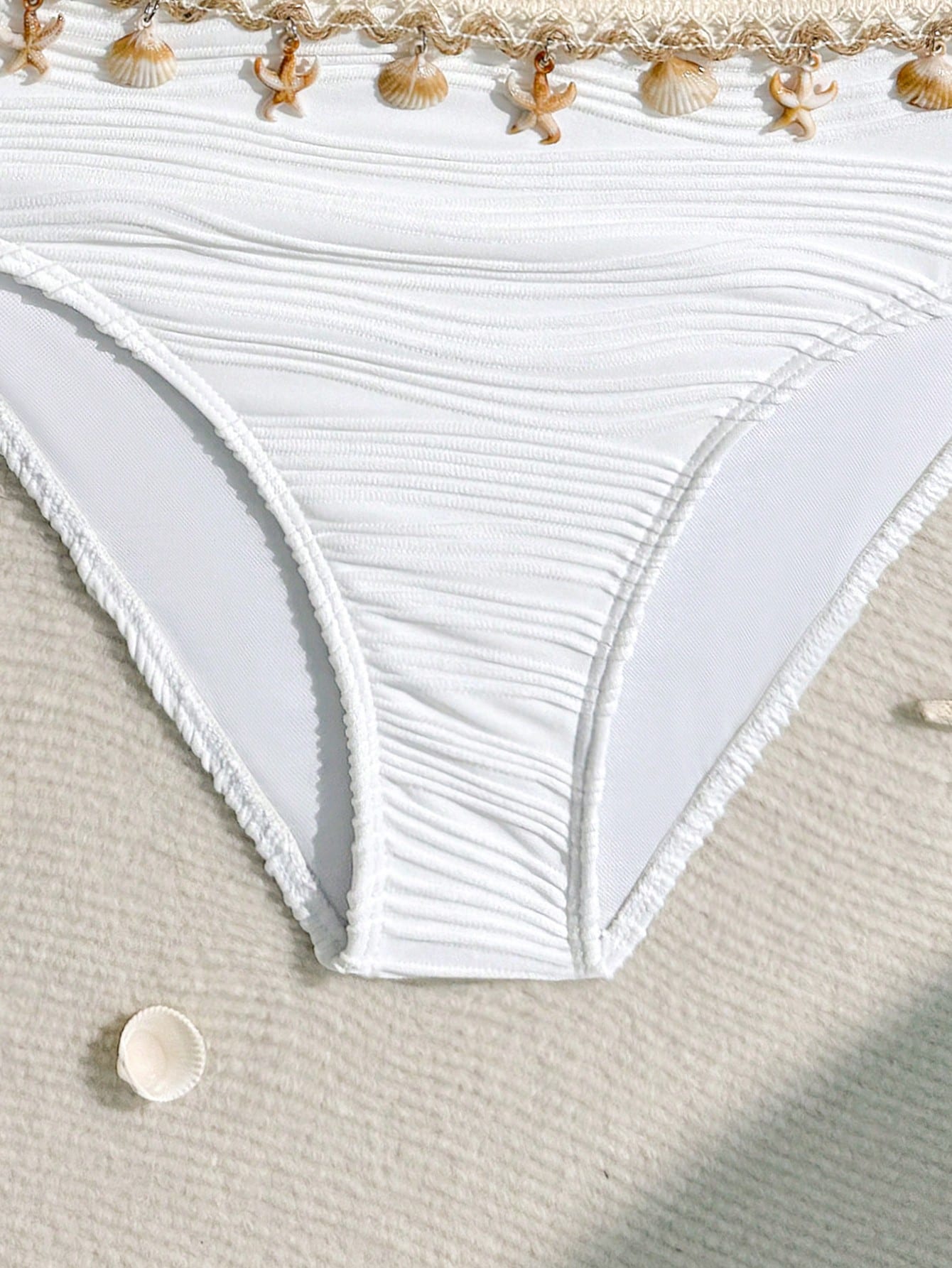 Tween girls bikini set with shell and starfish woven band details, spaghetti strap sleeveless top, and mid-waist skirt-style bottom in blue.