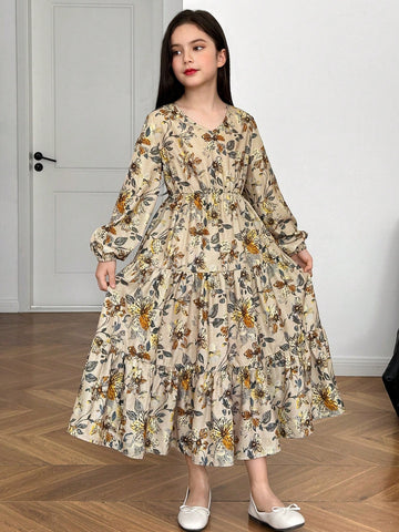 Tween girl wearing an apricot ditsy floral V-neck midi dress with long bishop puff sleeves, tiered ruffle layers, and a flounce hem.