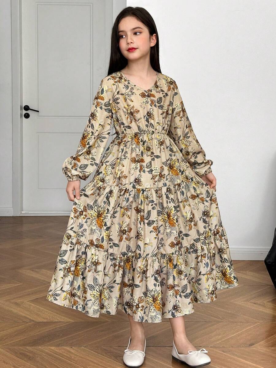 Tween girl wearing an apricot ditsy floral V-neck midi dress with long bishop puff sleeves, tiered ruffle layers, and a flounce hem.