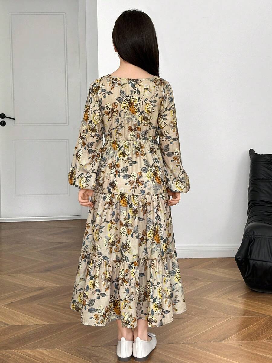 Tween girl wearing an apricot ditsy floral V-neck midi dress with long bishop puff sleeves, tiered ruffle layers, and a flounce hem.