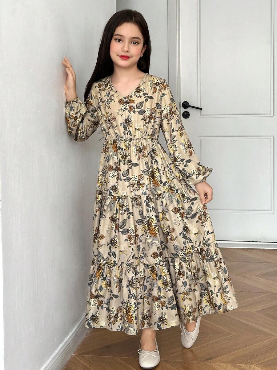 Tween girl wearing an apricot ditsy floral V-neck midi dress with long bishop puff sleeves, tiered ruffle layers, and a flounce hem.
