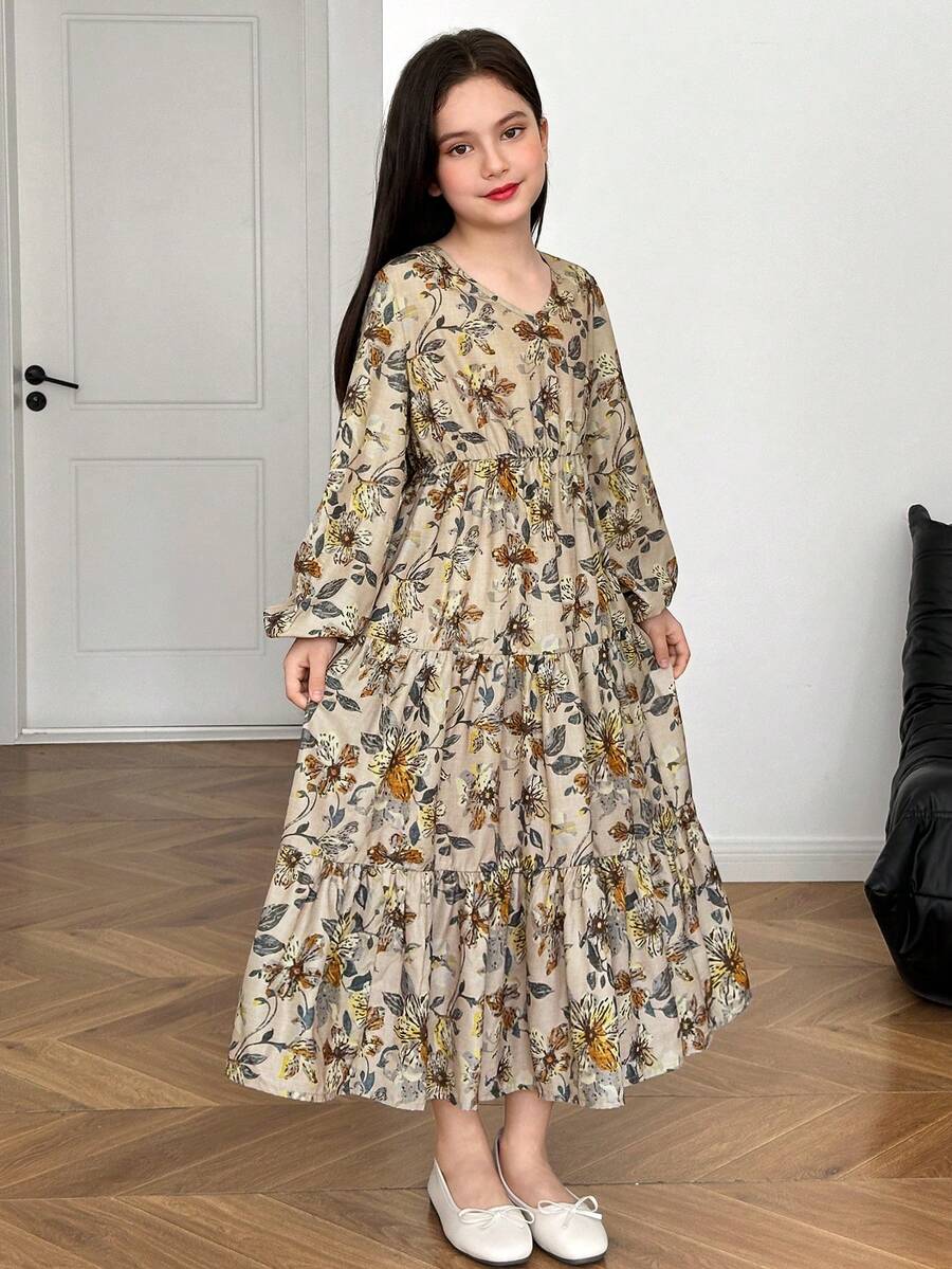 Tween girl wearing an apricot ditsy floral V-neck midi dress with long bishop puff sleeves, tiered ruffle layers, and a flounce hem.