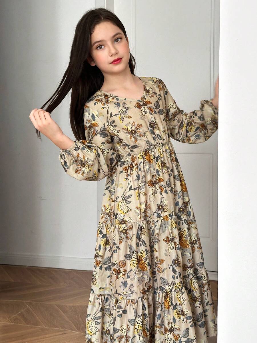 Tween girl wearing an apricot ditsy floral V-neck midi dress with long bishop puff sleeves, tiered ruffle layers, and a flounce hem.