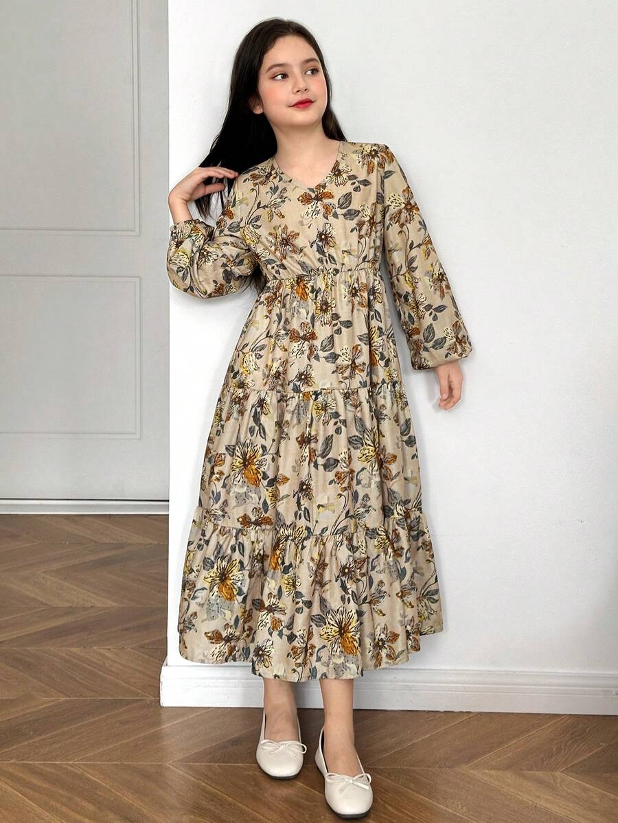 Tween girl wearing an apricot ditsy floral V-neck midi dress with long bishop puff sleeves, tiered ruffle layers, and a flounce hem.