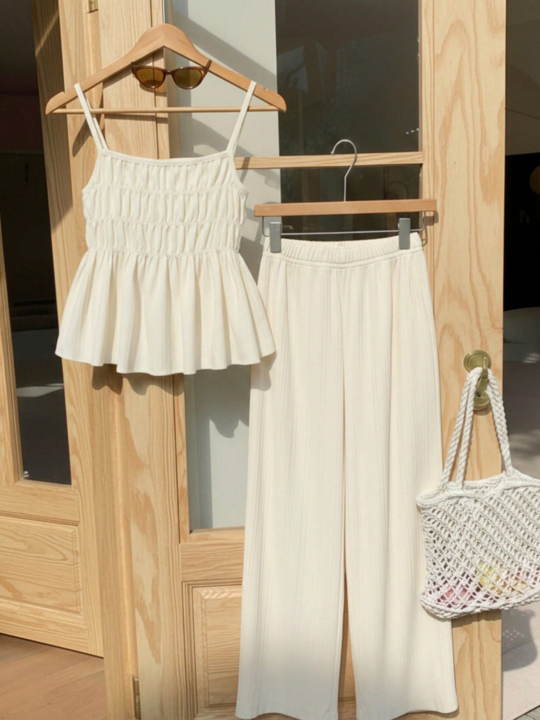 Tween girl wearing an apricot 2-piece outfit set featuring a shirred spaghetti strap short cami top and matching wide-leg long pants.