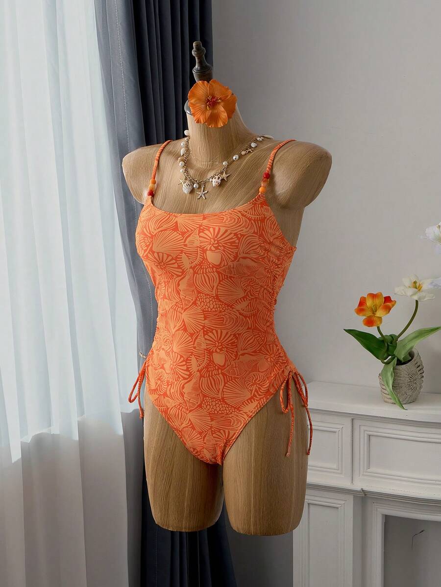 Women's blue backless one-piece swimsuit featuring spaghetti straps, wireless bra with removable padding, and drawstring details.