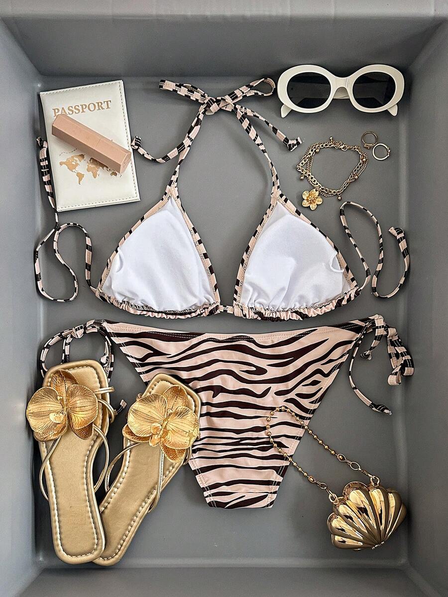 Women's black and white zebra print two-piece bikini set featuring a high waist tie-side bottom and a backless halter top with removable padding.