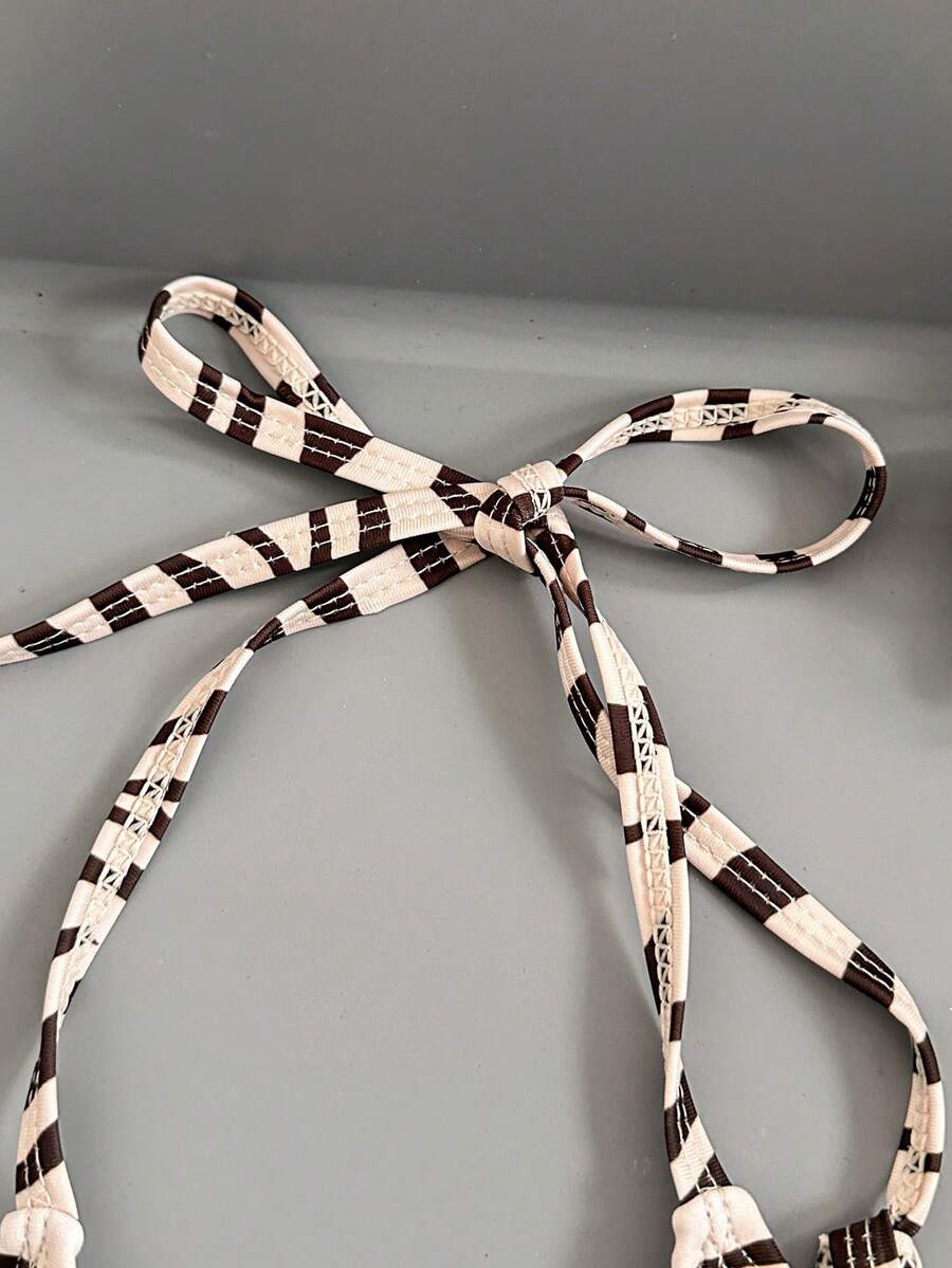 Women's black and white zebra print two-piece bikini set featuring a high waist tie-side bottom and a backless halter top with removable padding.