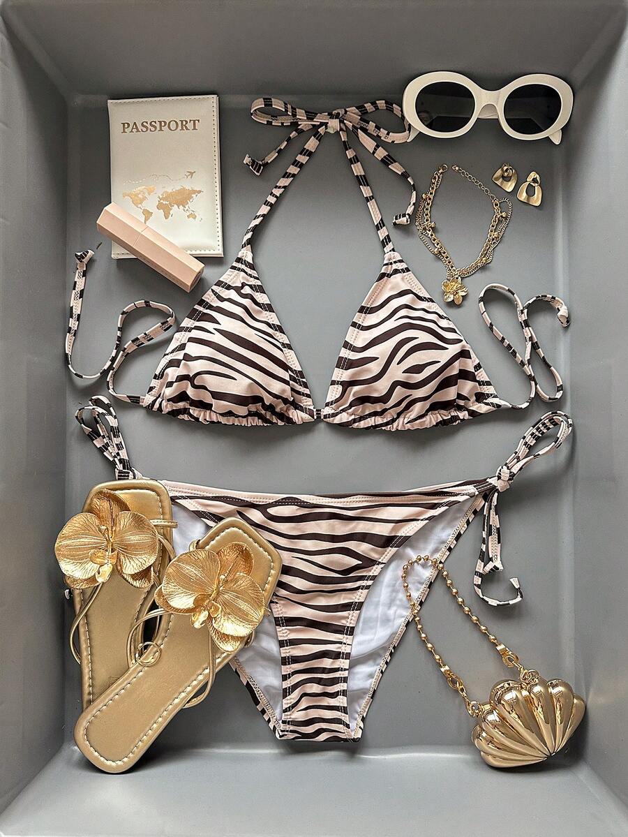 Women's black and white zebra print two-piece bikini set featuring a high waist tie-side bottom and a backless halter top with removable padding.