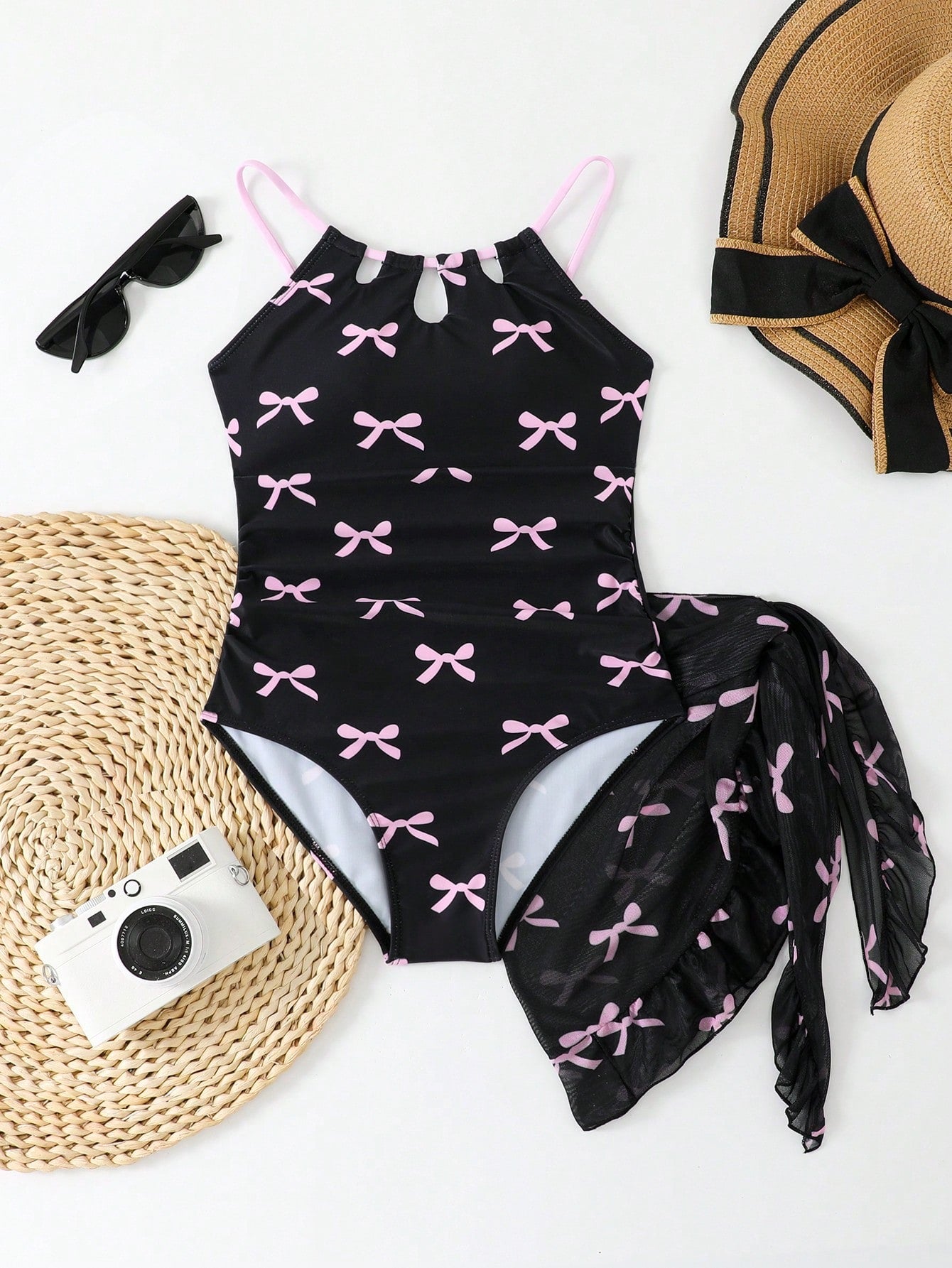 Girls black and white one-piece swimsuit set with cut-out detail, spaghetti straps, sleeveless fitted design, and matching skirt bottom for vacation swimwear.