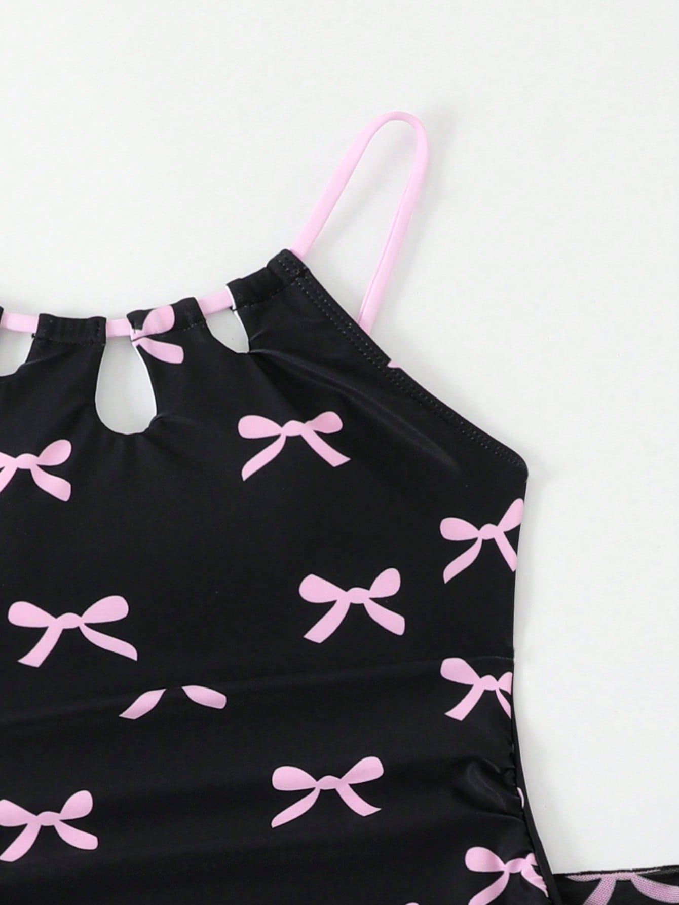 Girls black and white one-piece swimsuit set with cut-out detail, spaghetti straps, sleeveless fitted design, and matching skirt bottom for vacation swimwear.