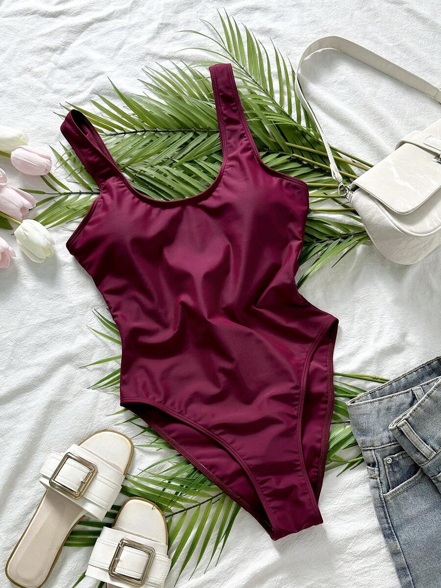 Women's solid color one-piece swimsuit featuring a backless scoop neck design and high cut fit