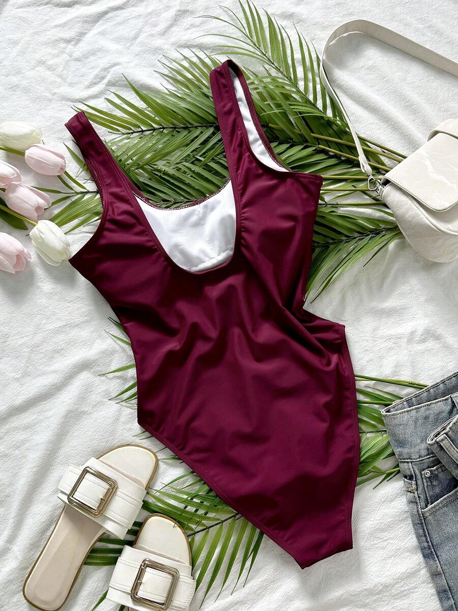 Women's solid color one-piece swimsuit featuring a backless scoop neck design and high cut fit