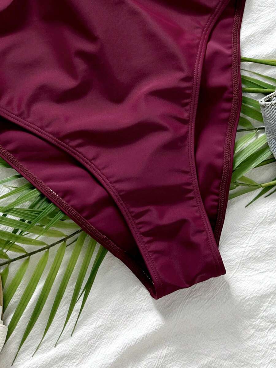 Women's solid color one-piece swimsuit featuring a backless scoop neck design and high cut fit