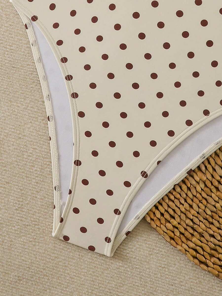 Women's apricot polka dot two-piece swimsuit featuring an asymmetrical halter backless top with knot tie detail and high-waisted bottoms.