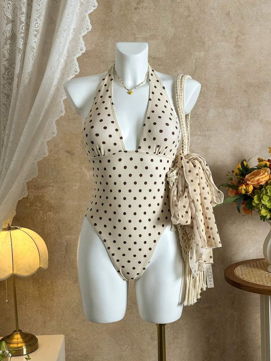 Women's apricot polka dot two-piece swimsuit featuring an asymmetrical halter backless top with knot tie detail and high-waisted bottoms.