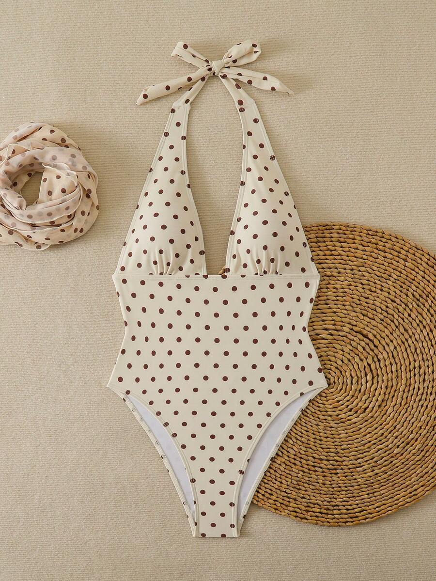 Women's apricot polka dot two-piece swimsuit featuring an asymmetrical halter backless top with knot tie detail and high-waisted bottoms.