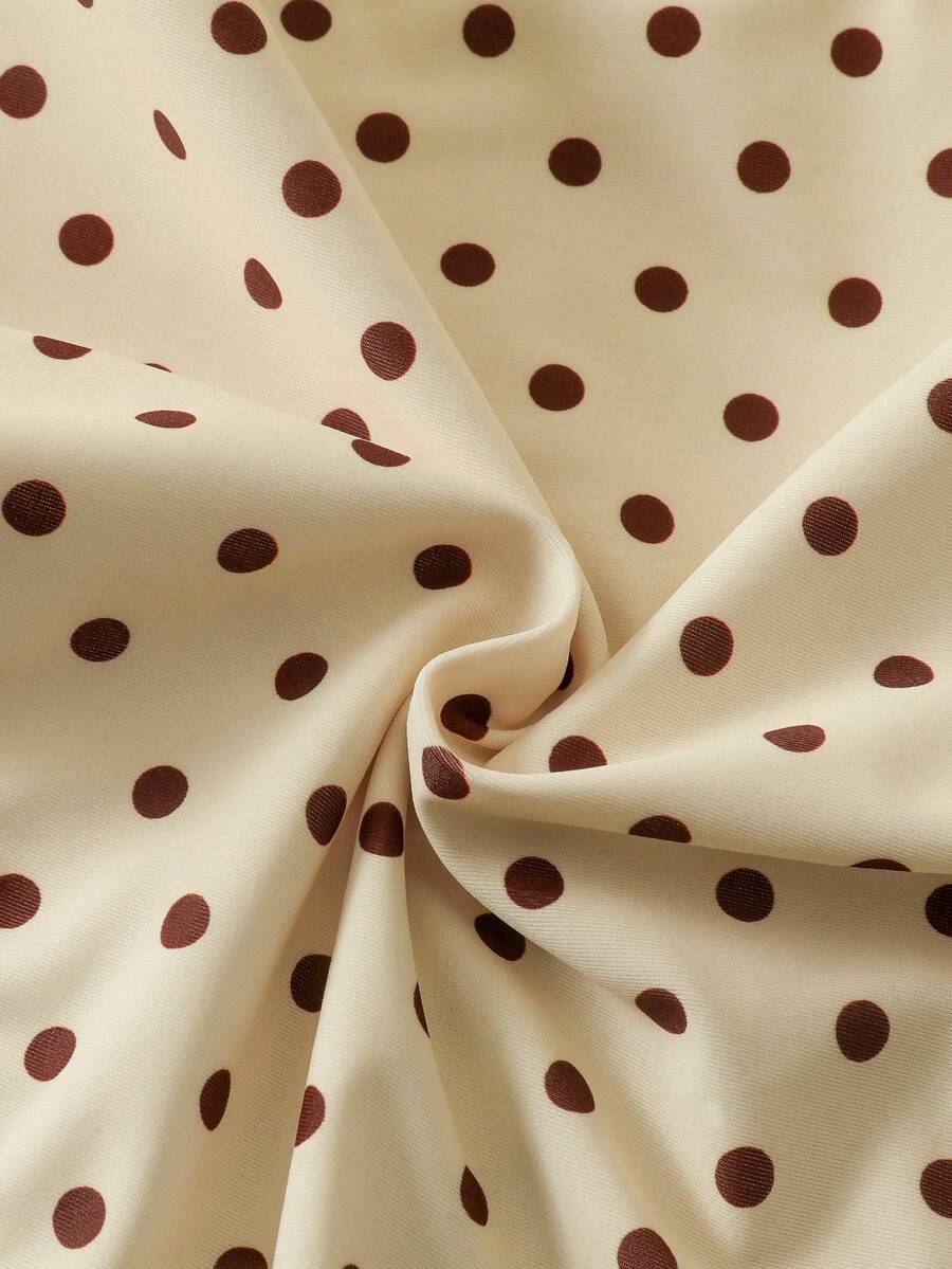 Women's apricot polka dot two-piece swimsuit featuring an asymmetrical halter backless top with knot tie detail and high-waisted bottoms.