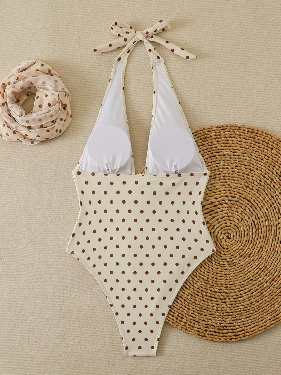 Women's apricot polka dot two-piece swimsuit featuring an asymmetrical halter backless top with knot tie detail and high-waisted bottoms.
