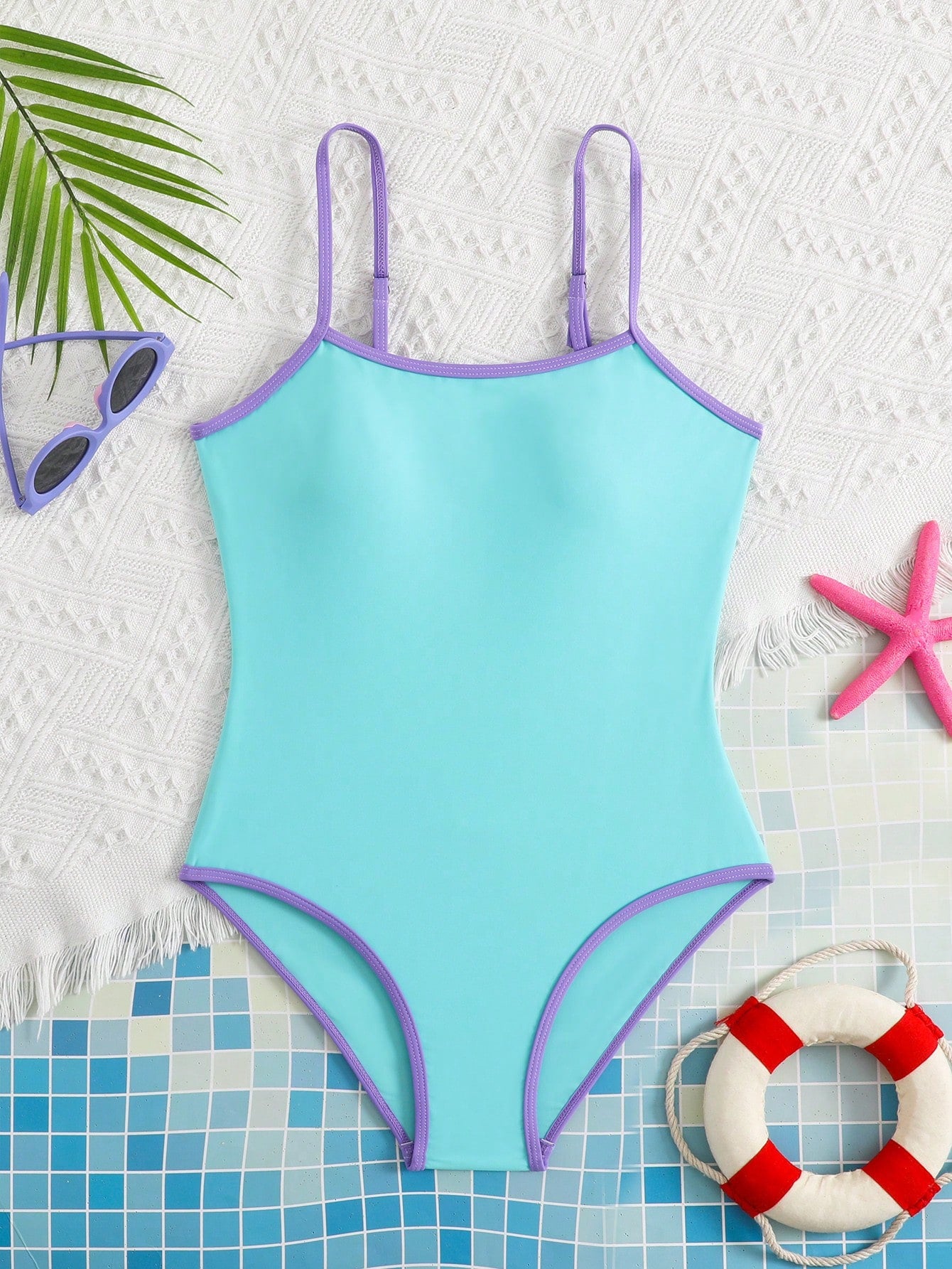 Tween girls one-piece swimsuit with a floral plant print, spaghetti straps, and a mid-waist fit in black.