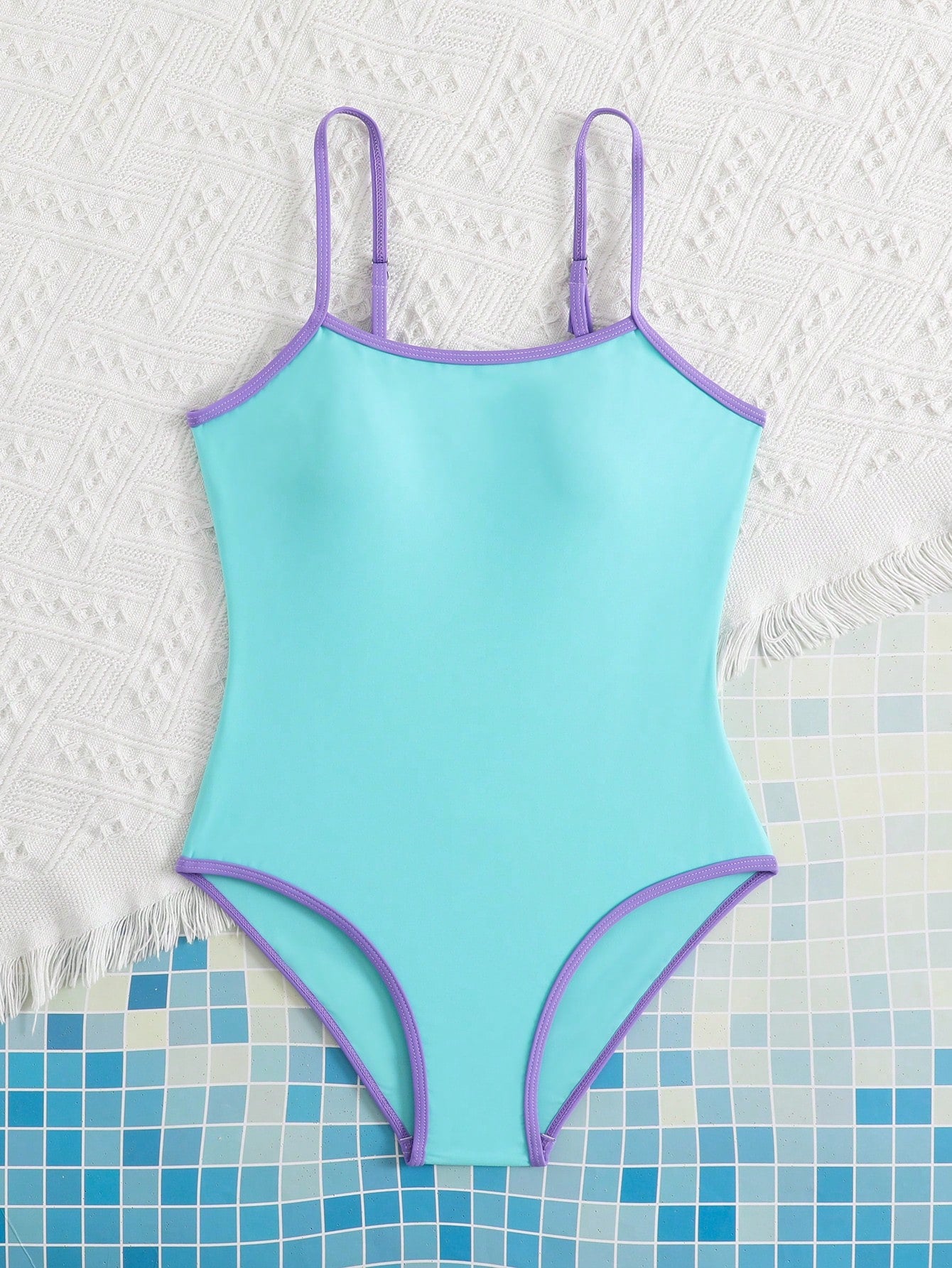 Tween girls one-piece swimsuit with a floral plant print, spaghetti straps, and a mid-waist fit in black.