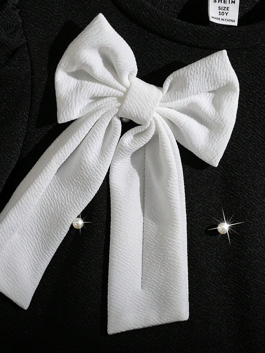 Tween girls apricot short-sleeve pleated smock dress with 3D bow decor and round neckline.
