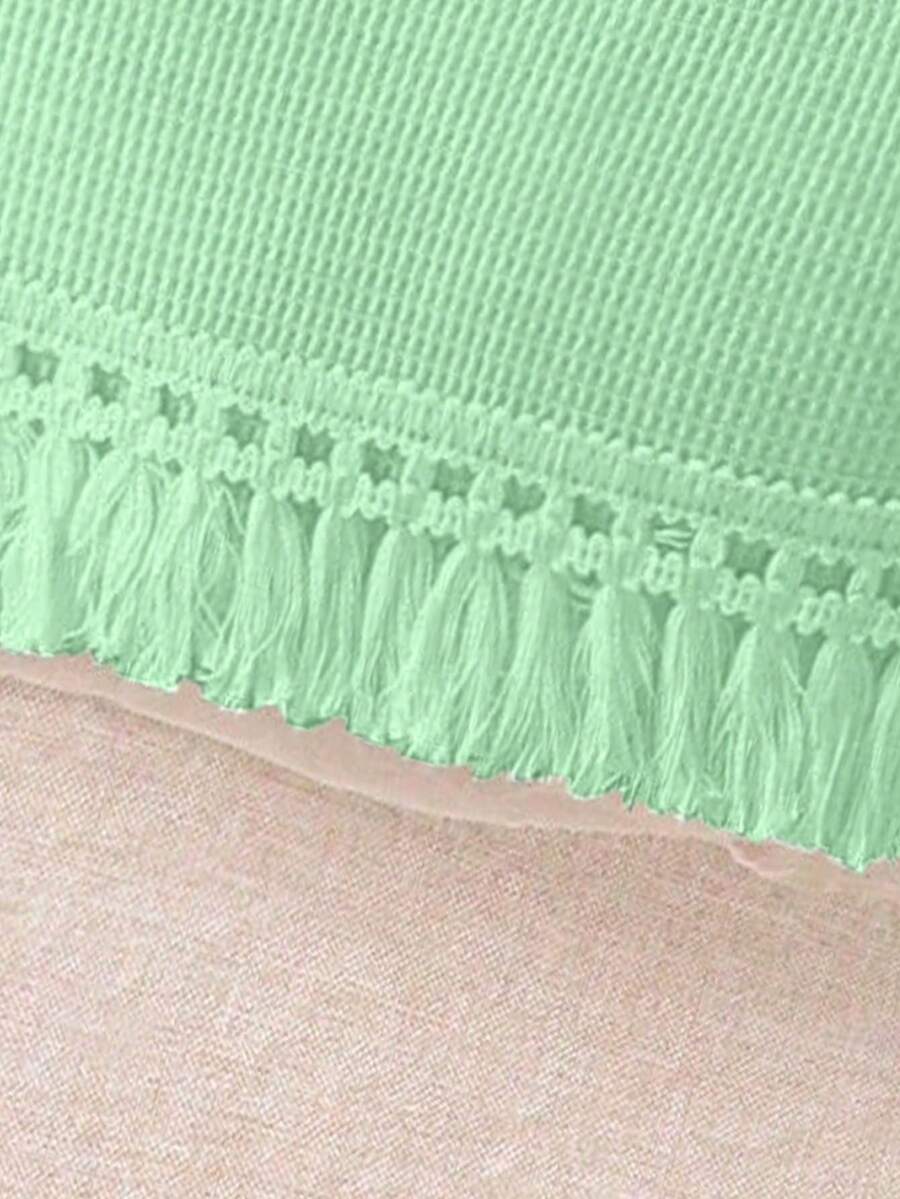 Girls' sleeveless summer midi dress with halter neckline, geometric pattern, applique and fringe details, shown with crossbody bag accessory with tassel decor