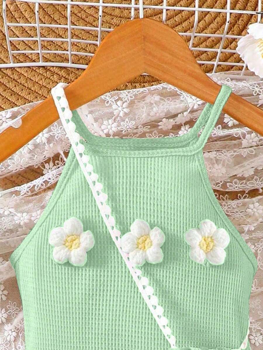 Girls' sleeveless summer midi dress with halter neckline, geometric pattern, applique and fringe details, shown with crossbody bag accessory with tassel decor