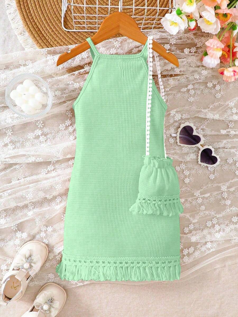Girls' sleeveless summer midi dress with halter neckline, geometric pattern, applique and fringe details, shown with crossbody bag accessory with tassel decor